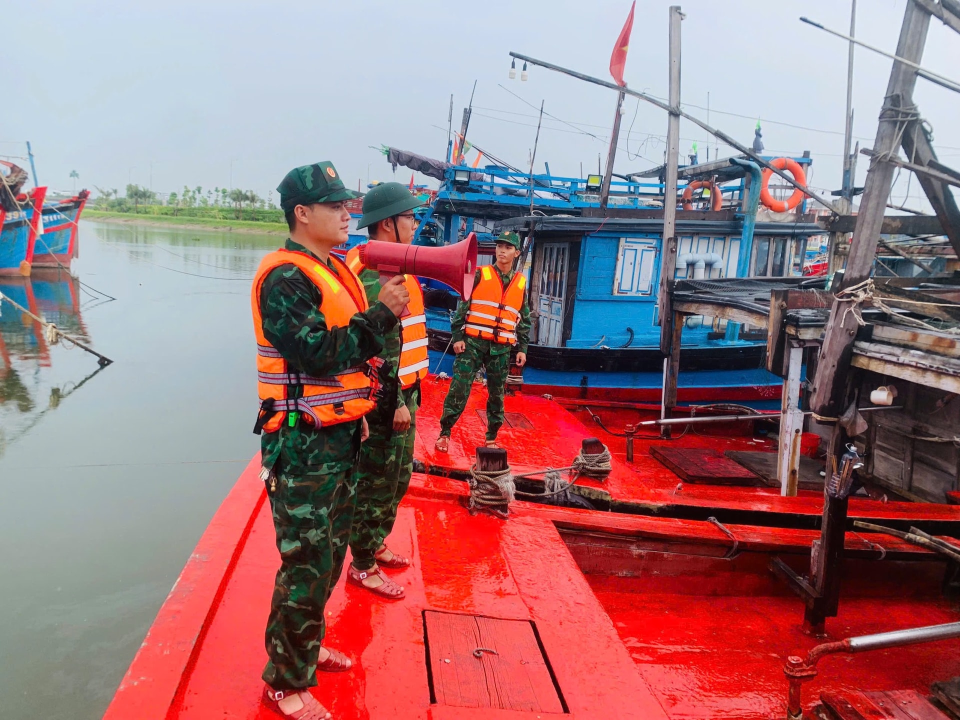 Bộ đội Biên Phòng Đà Nẵng tuyên truyền phòng chống bão số 5 tới các chủ tàu thuyền trong khu neo đậu tránh trú bão. Ảnh: Đà Thành.