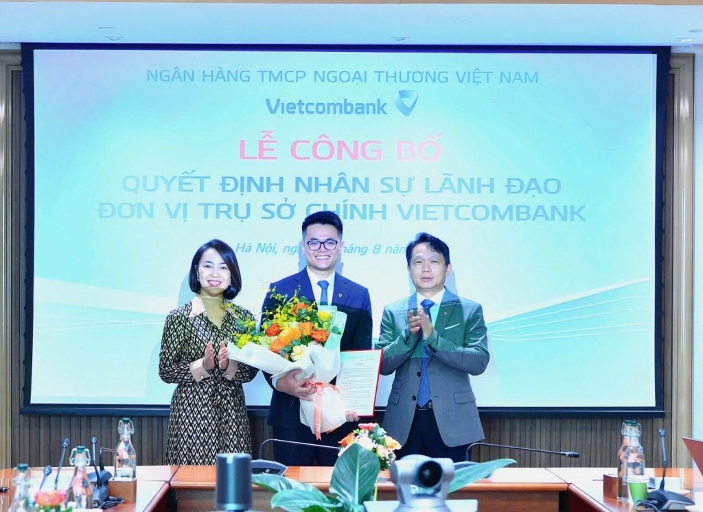 Ông Nguyễn Mạnh Hùng - Thành viên HĐQT Vietcombank (bên phải) trao Quyết định bổ nhiệm và bà Nguyễn Thị Kim Oanh - Thành viên HĐQT Vietcombank tặng hoa chúc mừng ông Hà Vinh Hiển - tân Phó Trưởng Ban Chiến lược và thư ký HĐQT Vietcombank