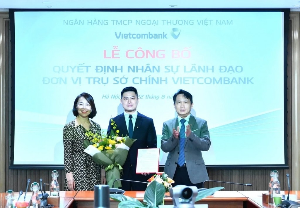Ông Nguyễn Mạnh Hùng - Thành viên HĐQT Vietcombank (bên phải) trao Quyết định bổ nhiệm và bà Nguyễn Thị Kim Oanh - Thành viên HĐQT Vietcombank tặng hoa chúc mừng ông Chử Ngọc Linh - tân Phó Trưởng Ban Chiến lược và thư ký HĐQT Vietcombank