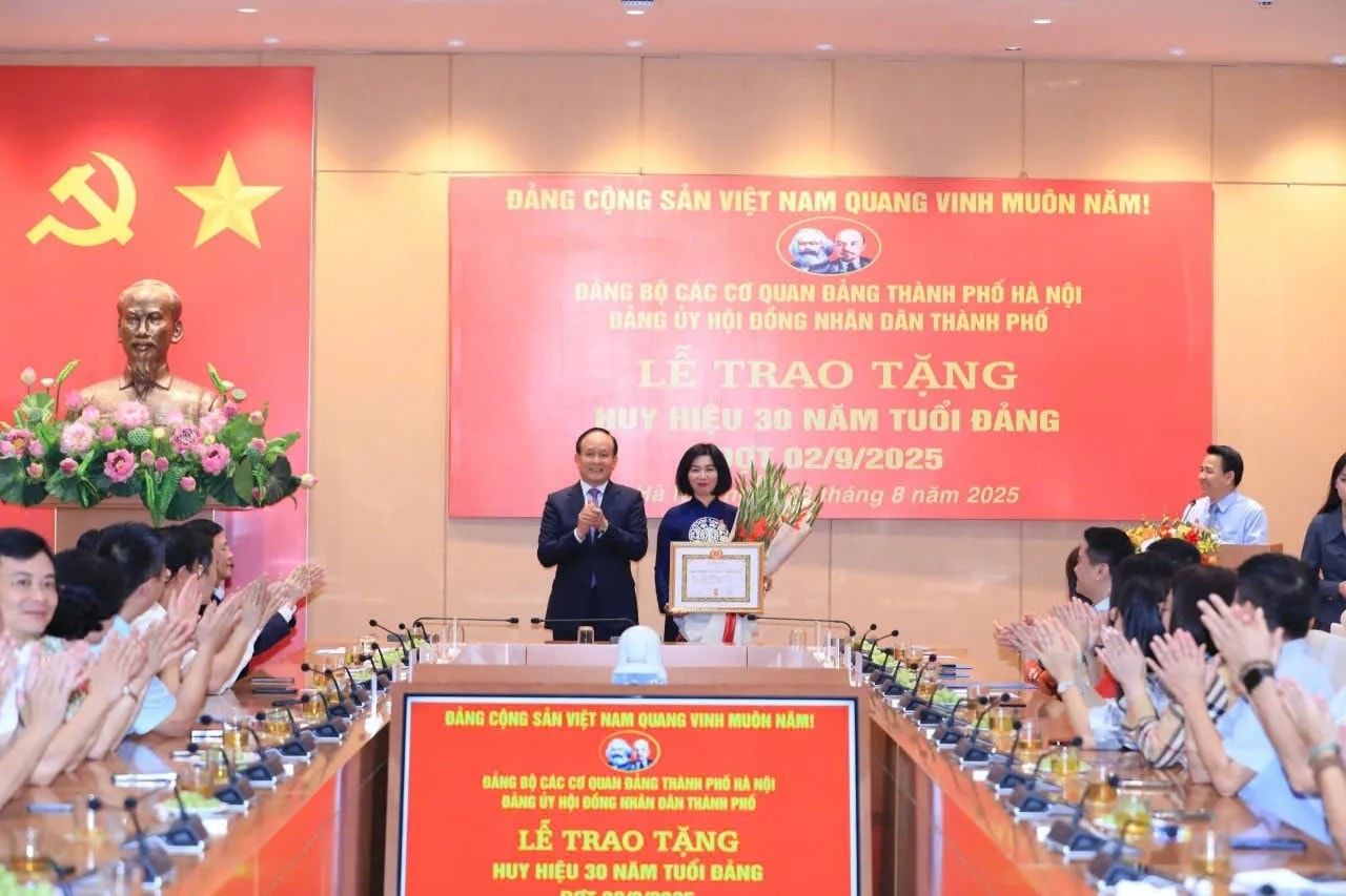 Đồng chí Nguyễn Ngọc Tuấn trao Huy hiệu, chúc mừng đồng chị Phùng Thị Hồng Hà