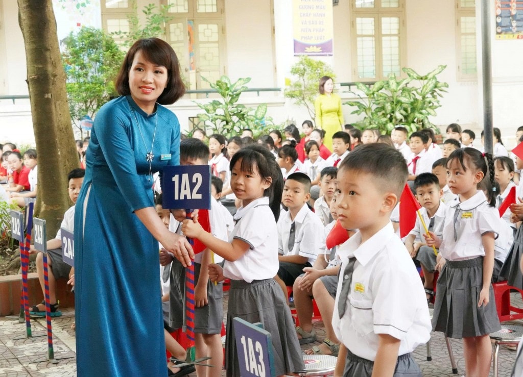 Học sinh lớp 1 Trường Tiểu học Biên Giang được cô hiệu trưởng đón chào 