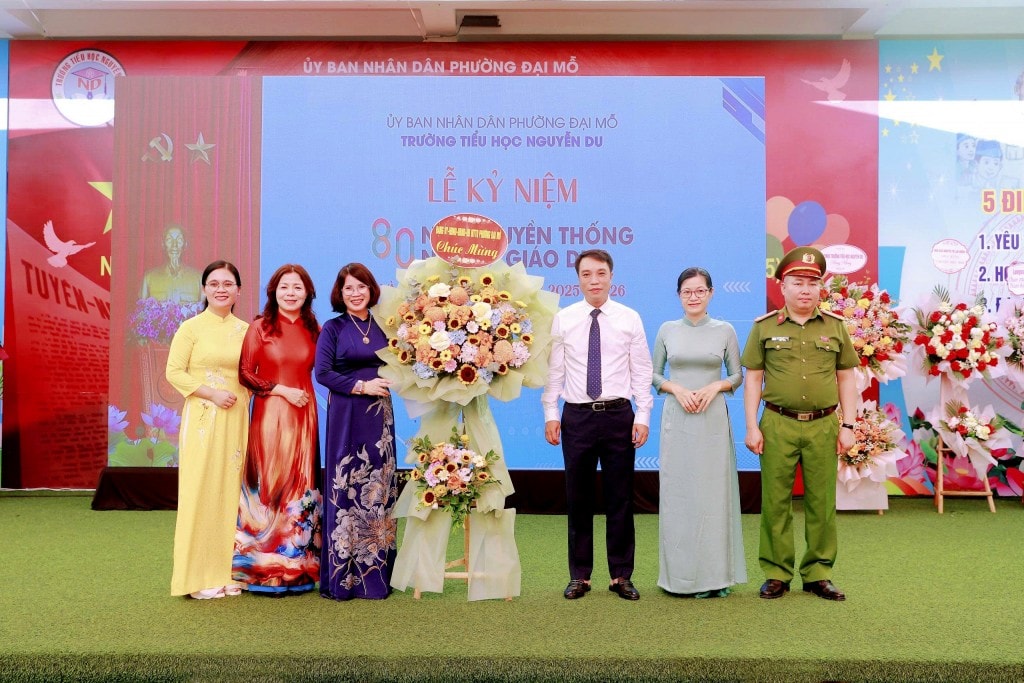 Đồng chí Phùng Ngọc Sơn - Phó Bí thư Đảng ủy, Chủ tịch UBND phường Đại Mỗ cùng đoàn công tác tặng hoa chúc mừng thầy và trò trường Tiểu học Nguyễn Du