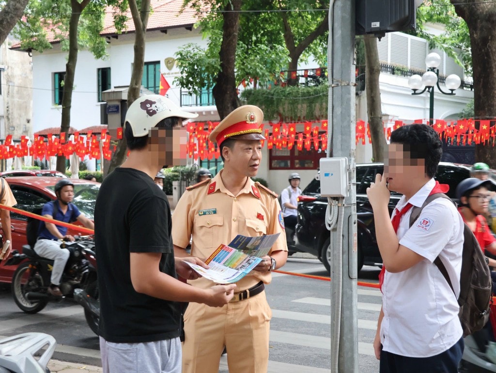 Cảnh sát giao thông phát tờ rơi, tuyên truyền trực tiếp cho phụ huynh và học sinh về an toàn giao thông