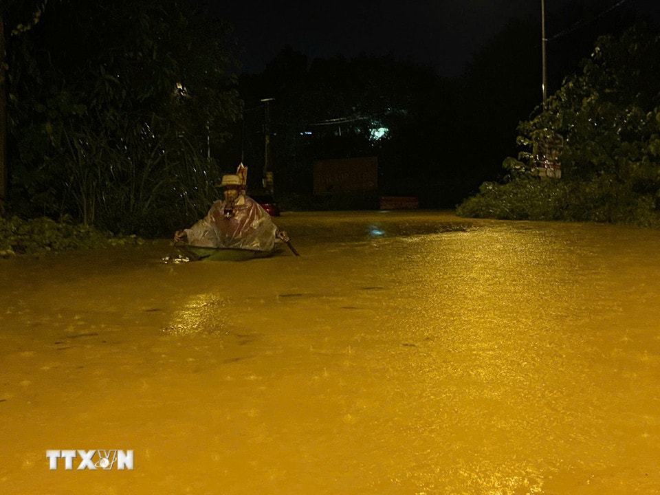 Một số hộ dân di chuyển tạm thời bằng thuyền nhựa qua các khu vực ngập sâu đến nơi an toàn. (Ảnh: Đinh Thùy/TTXVN)