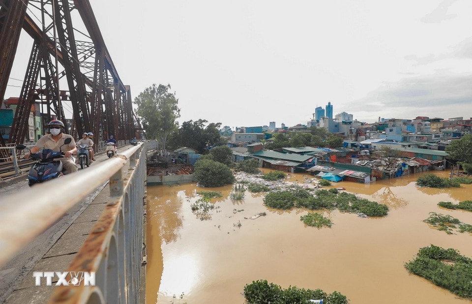 Khu dân cư sát chân cầu - gần chợ Long Biên chiều nay nhiều nhà đã ngập sâu trong nước. (Ảnh: Phan Phương/TTXVN)