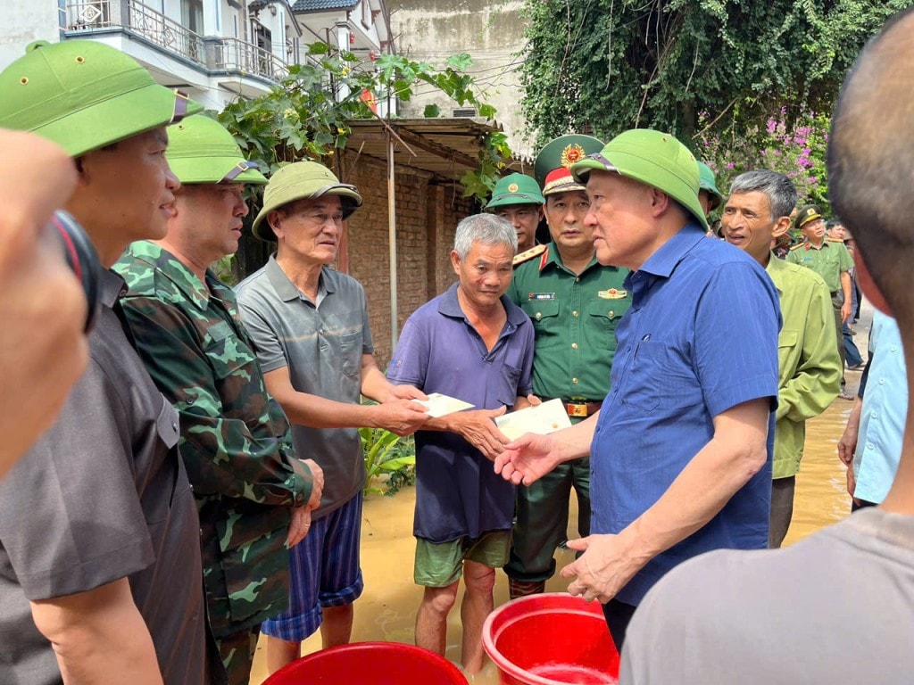 Phó Thủ tướng Thường trực Chính phủ Nguyễn Hoà Bình tặng quà cho người dân bị ảnh hưởng do ngập lụt tại xã Tiên Lục - Ảnh: VGP/Nguyễn Hoàng