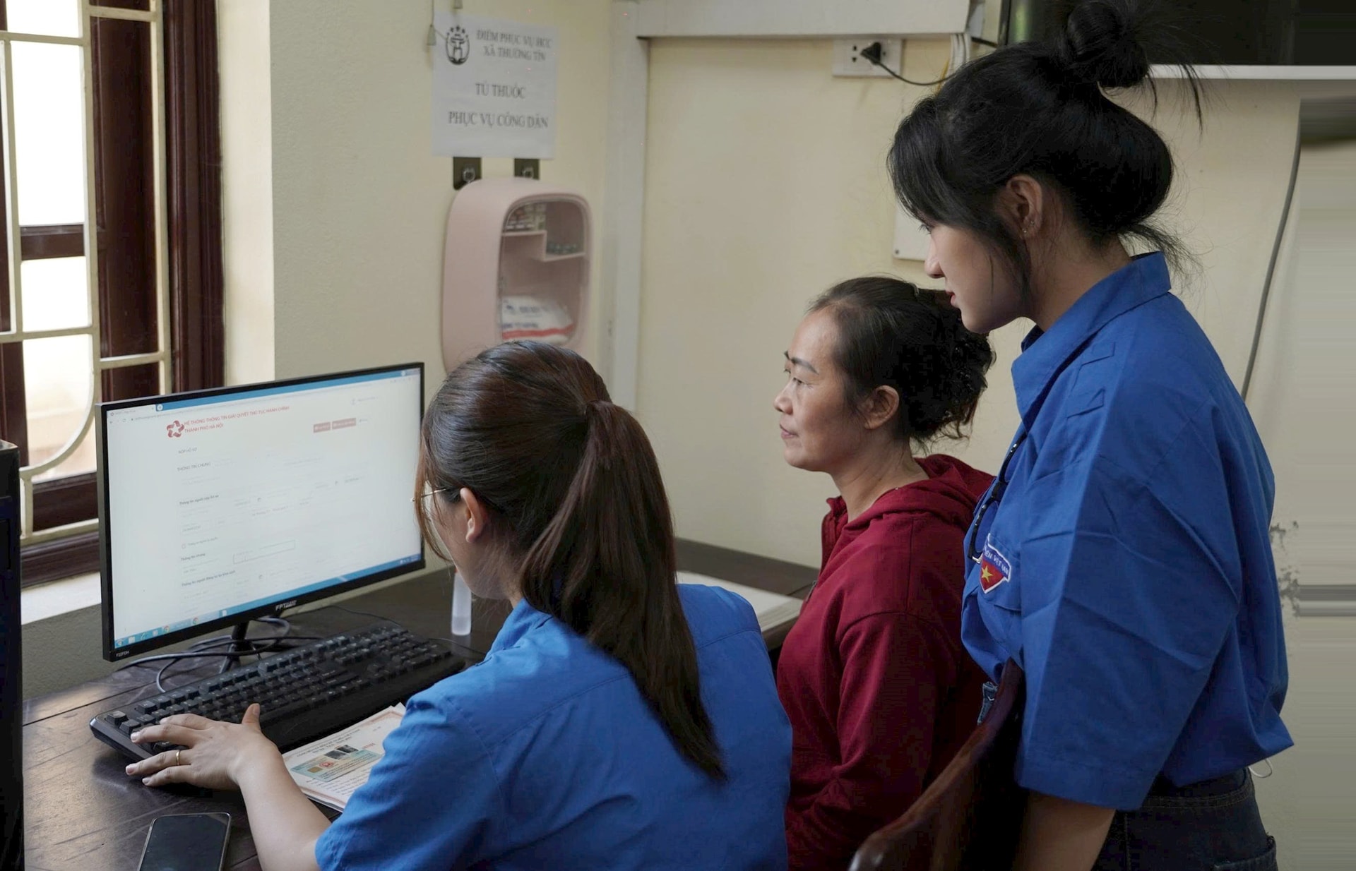 Medlemmar i ungdomsförbund stöder människor i att utföra procedurer vid handelskommunens administrativa servicepunkt.-anh-to-quy.jpg