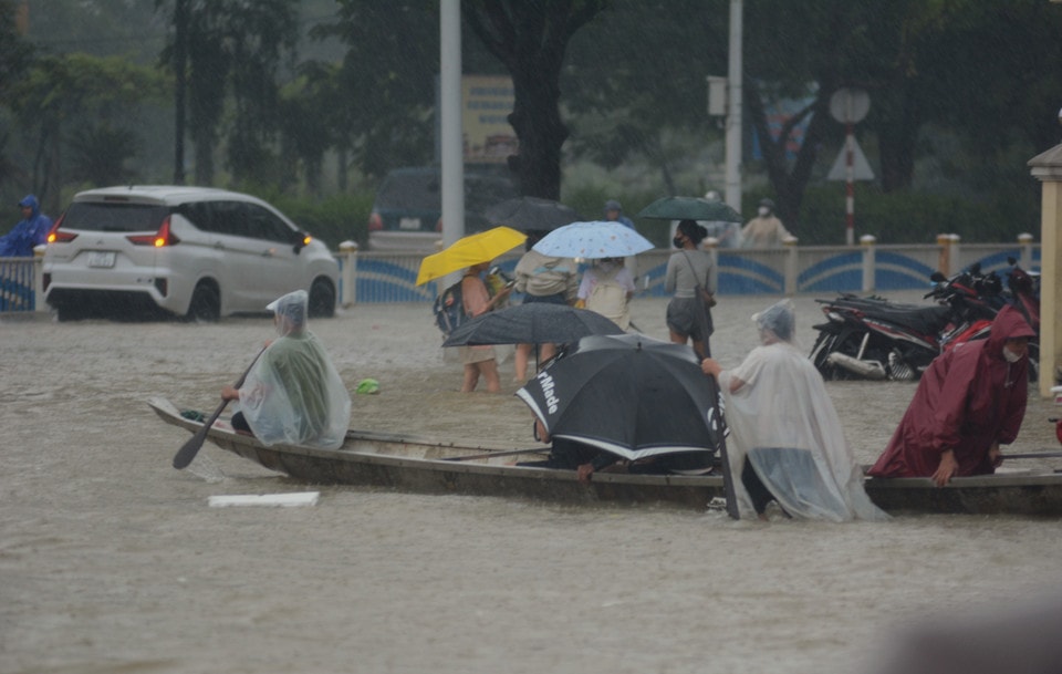 Nhiều người chọn đi bằng thuyền để đi qua các đoạn đường ngập sâu. (Ảnh: Văn Dũng/TTXVN)