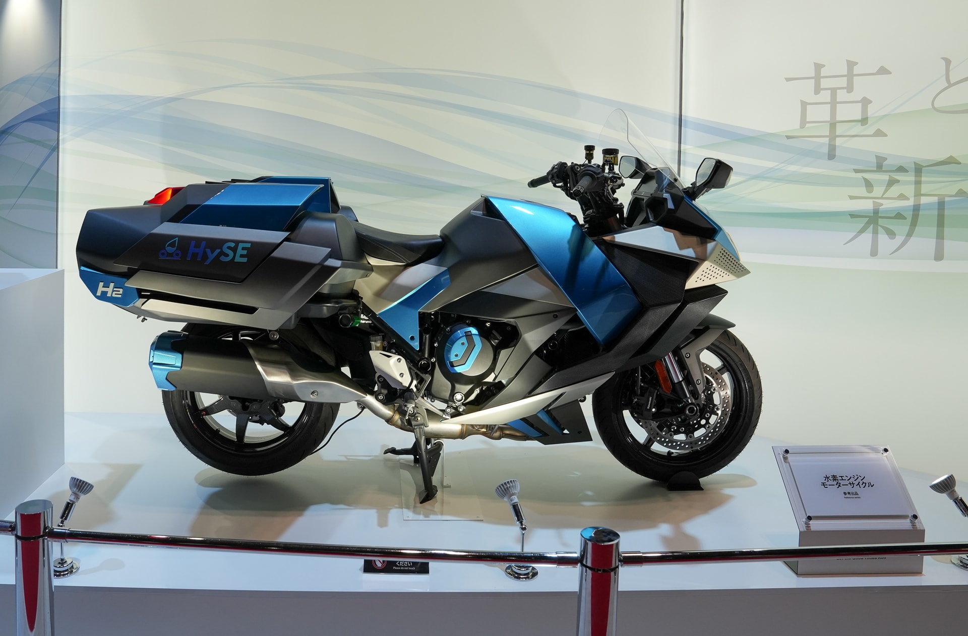 Cách tiếp cận của Kawasaki lại là xe mô tô sử dụng nhiên liệu hydrogen với tham vọng duy trì cảm giác lái động cơ đốt trong dù vẫn hướng tới giảm phát thải. Chiếc Ninja H2 HySE được trưng bày tại JMS 2025 đã nhiều lần xuất hiện trên đường đua. Xe sử dụng động cơ đốt trong 998cc với bộ nạp khí được tinh chỉnh để đảm bảo lượng ô xy cung cấp đủ để kích hoạt nhiên liệu hydro tạo ra động lực cao.