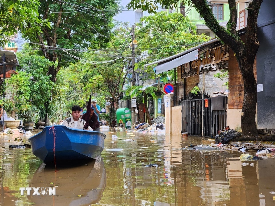 Người dân vẫn phải di chuyển bằng ghe trên đường trong chiều 1/11. (Ảnh: Mai Trang/TTXVN)