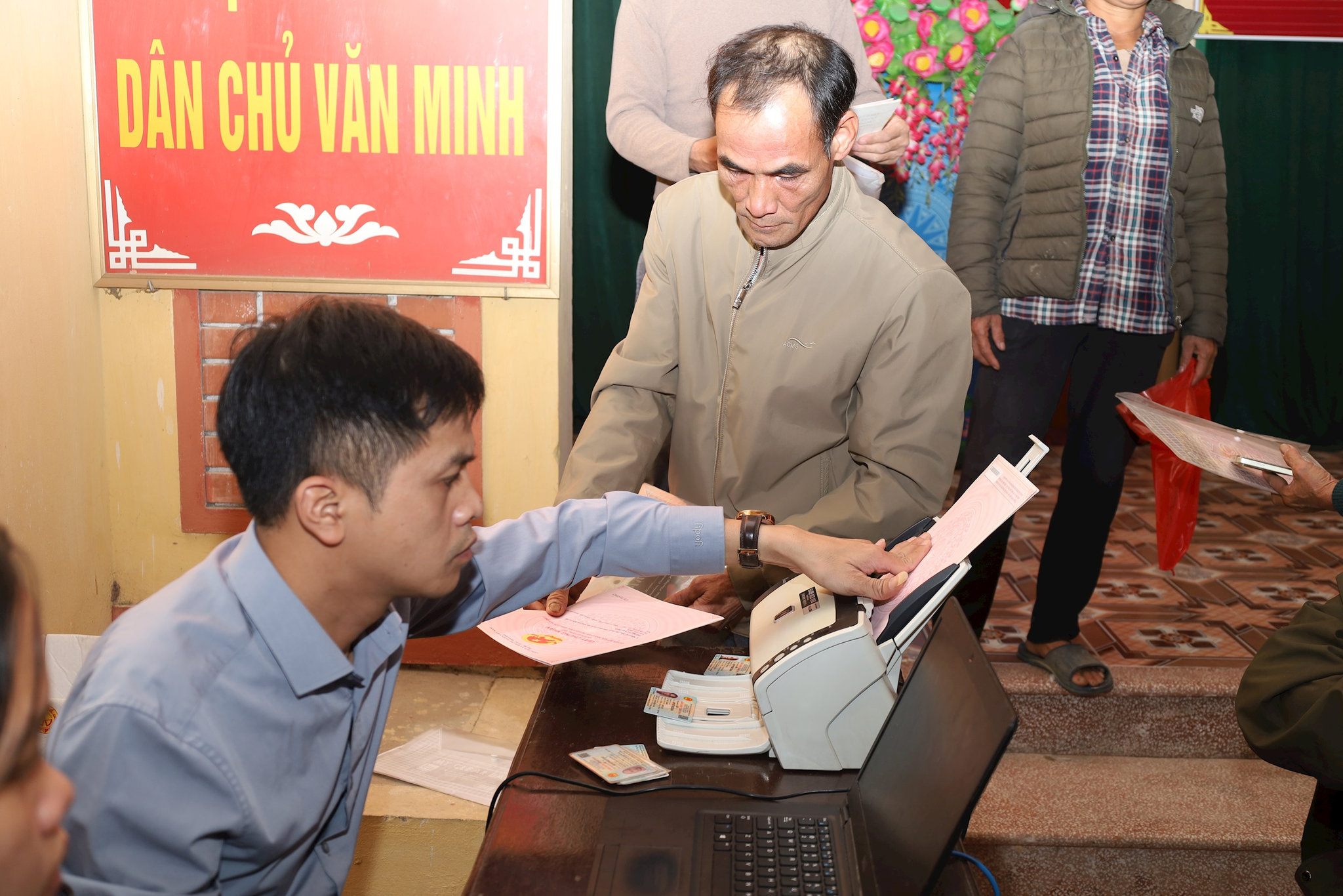 Người dân xã Hòa Phú không phải phô tô sổ đỏ, cán bộ xã scan bản chính để nhập dữ liệu. Ảnh: Kim Nhuệ