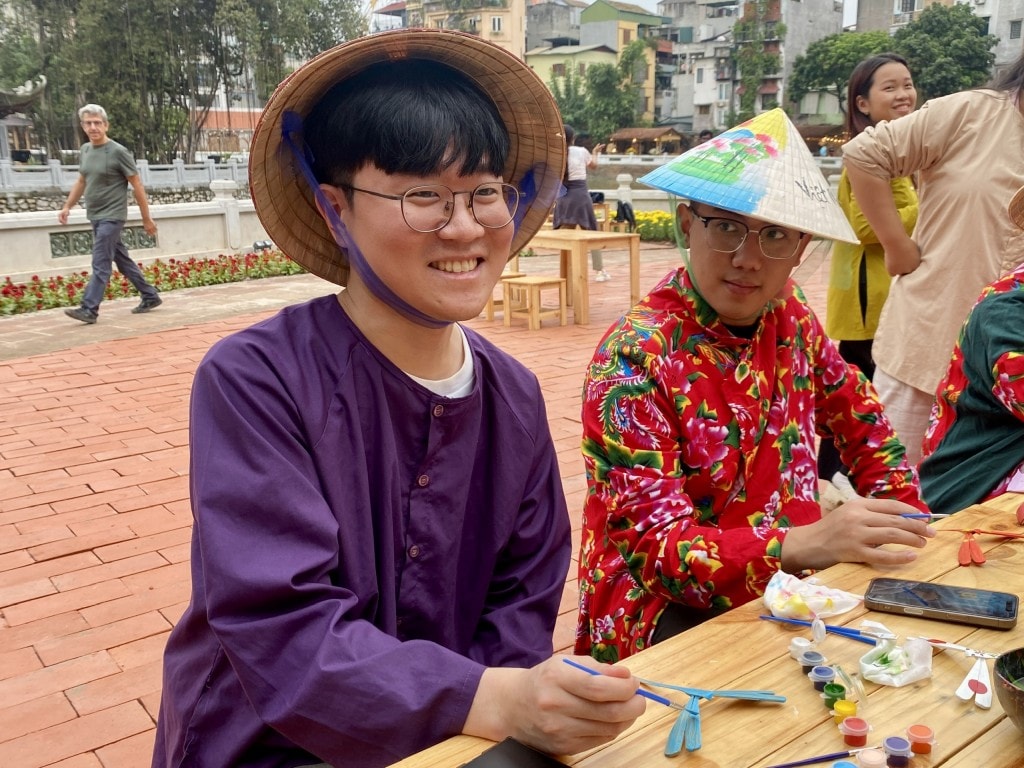 Anh Geon Hui (25 tuổi, du học sinh Hàn Quốc) chăm chú trải nghiệm hoạt động hoàn thiện chuồn chuồn tre truyền thống
