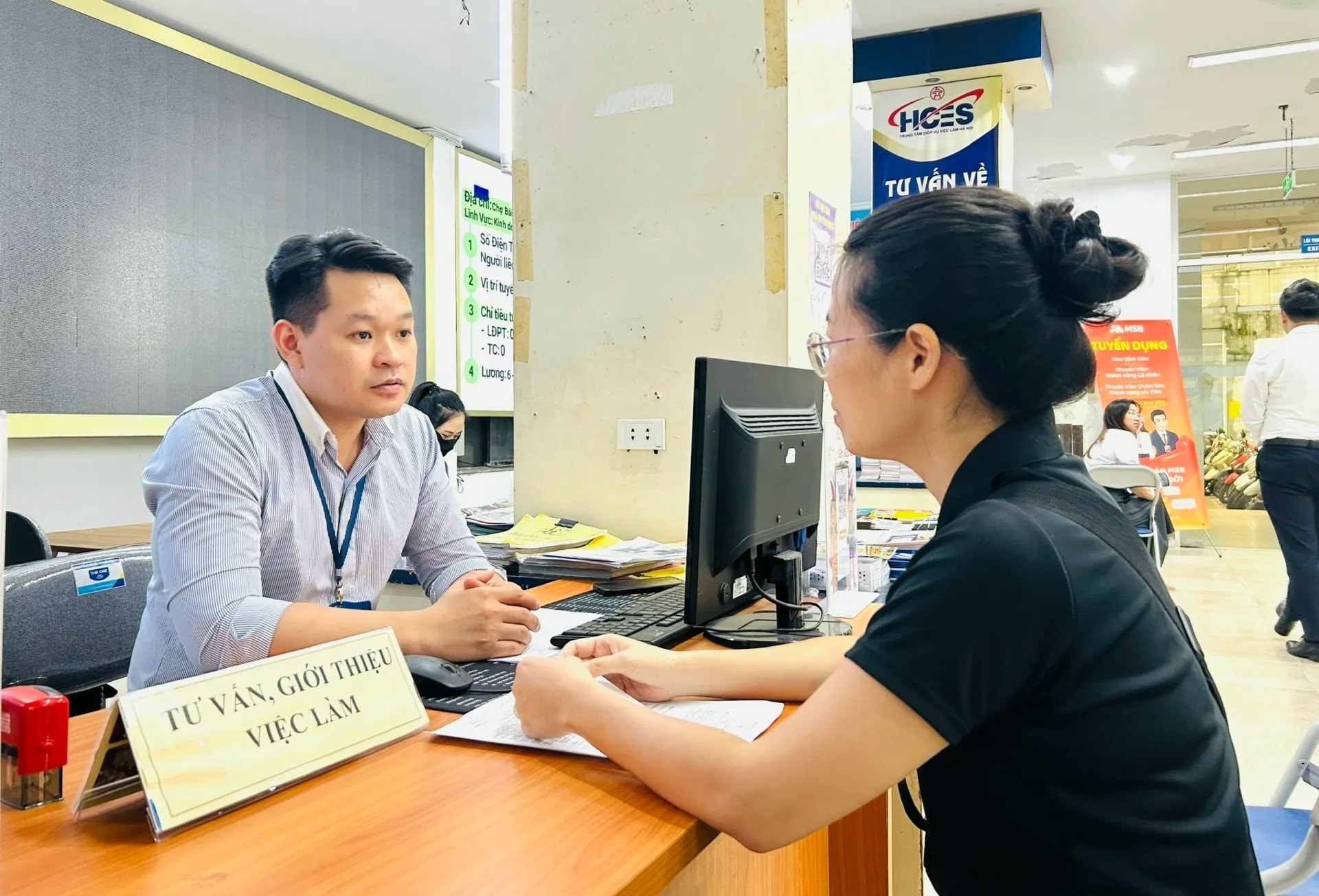 Người lao động trung tuổi được cán bộ Trung tâm Dịch vụ việc làm Hà Nội tư vấn, giới thiệu việc làm (Ảnh: Trần Oanh)