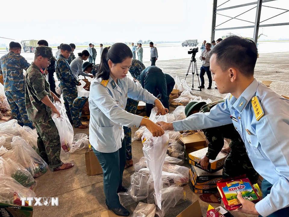 Lương thực, thực phẩm, nhu yếu phẩm được vận chuyển, sắp xếp lên máy bay để chuyển đến người dân vùng lũ ở Nam Trung Bộ. (Ảnh: Trần Lê Lâm/TTXVN)