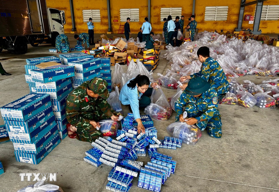 Hàng hóa, lương thực, nhu yếu phẩm được vận chuyển, sắp xếp lên máy bay để hỗ trợ người dân khu vực ngập lụt. (Ảnh: Trần Lê Lâm/TTXVN)