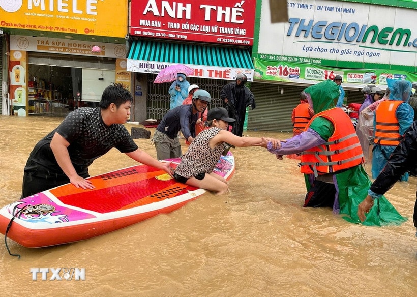 Sử dụng thuyền kayak đưa người dân vùng ngập lụt bị cô lập đến nơi an toàn. (Ảnh: Phan Sáu/TTXVN)