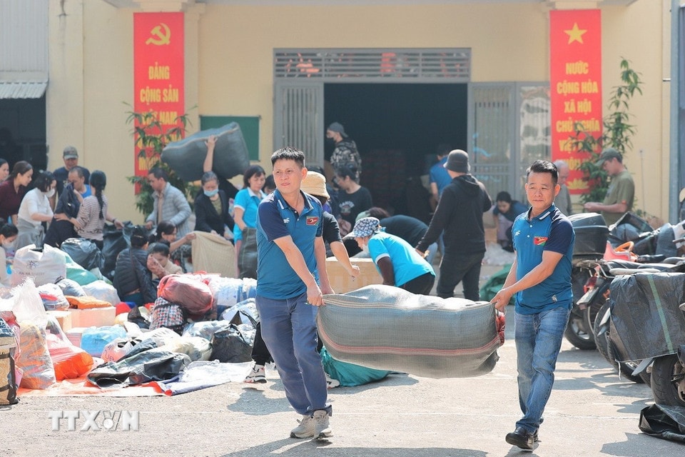 Tình nguyện viên vận chuyển hàng ra nơi tập kết vận chuyển hỗ trợ miền Trung tại điểm 105 Xuân La. (Ảnh: Lê Đông/TTXVN)