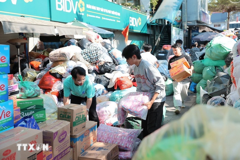 Tình nguyện viên đóng gói nhu yếu phẩm để gửi tới đồng bào miền Trung tại điểm Ô Chợ Dừa. (Ảnh: Lê Đông/TTXVN)