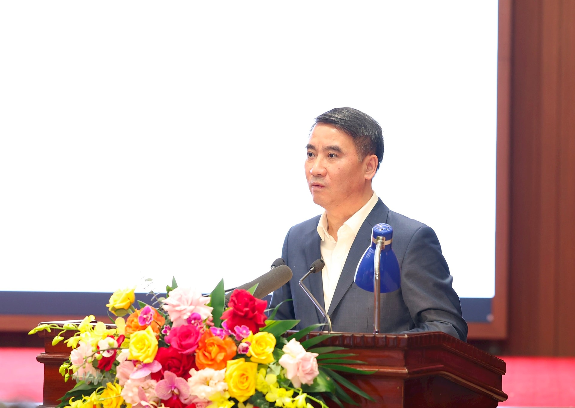 Phó Chủ tịch UBND thành phố Hà Nội Nguyễn Xuân Lưu trình bày tóm tắt Báo cáo tổng hợp chung về kinh tế - xã hội, tài chính - ngân sách và đầu tư công. Ảnh: Viết Thành