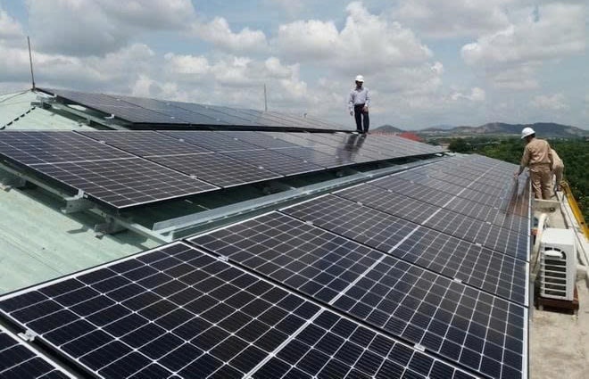 Hanoi Electricity Corporation staff support customers in installing solar power system for their homes..jpg