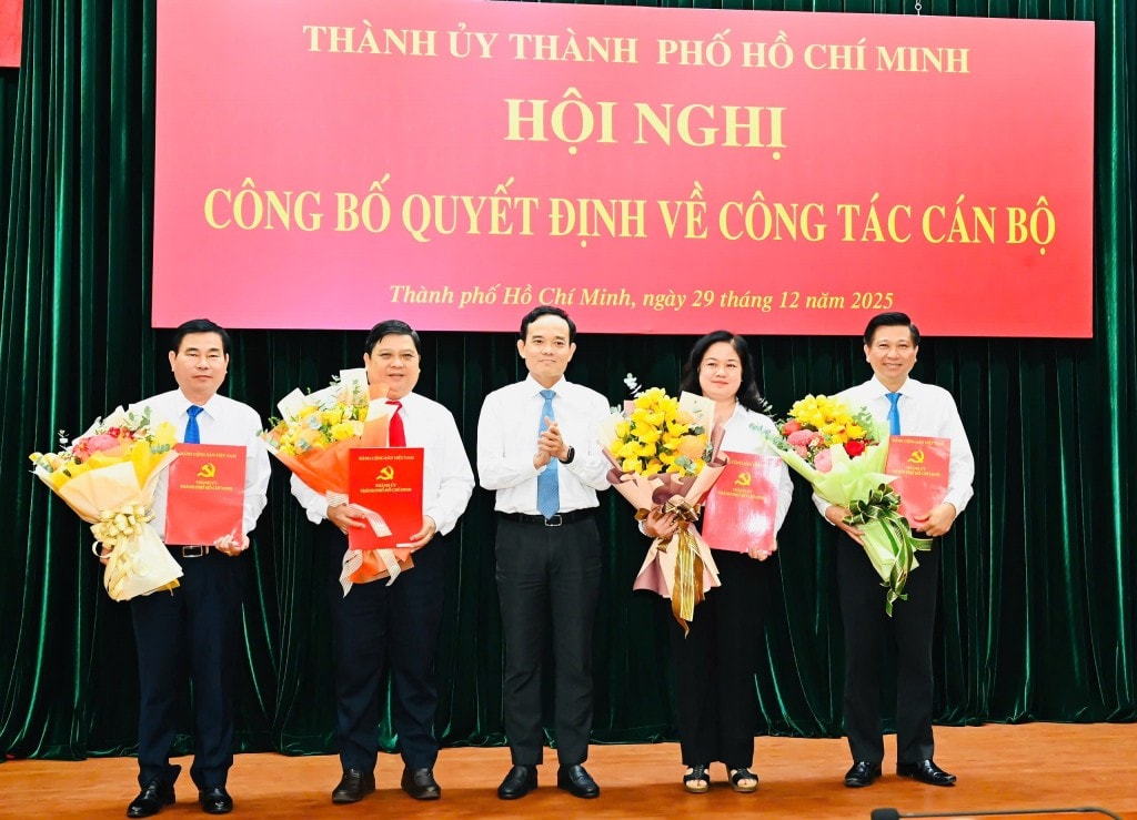 Bí thư Thành ủy TP Hồ Chí Minh Trần Lưu Quang trao quyết định, tặng hoa chúc mừng các đồng chí Ủy viên Ban Thường vụ Thành ủy nhận nhiệm vụ mới (Ảnh: Việt Dũng)