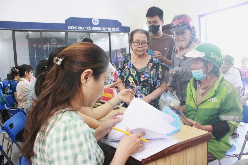 Người dân nhận tiền trợ cấp xã hội (Ảnh: Hải Châu)