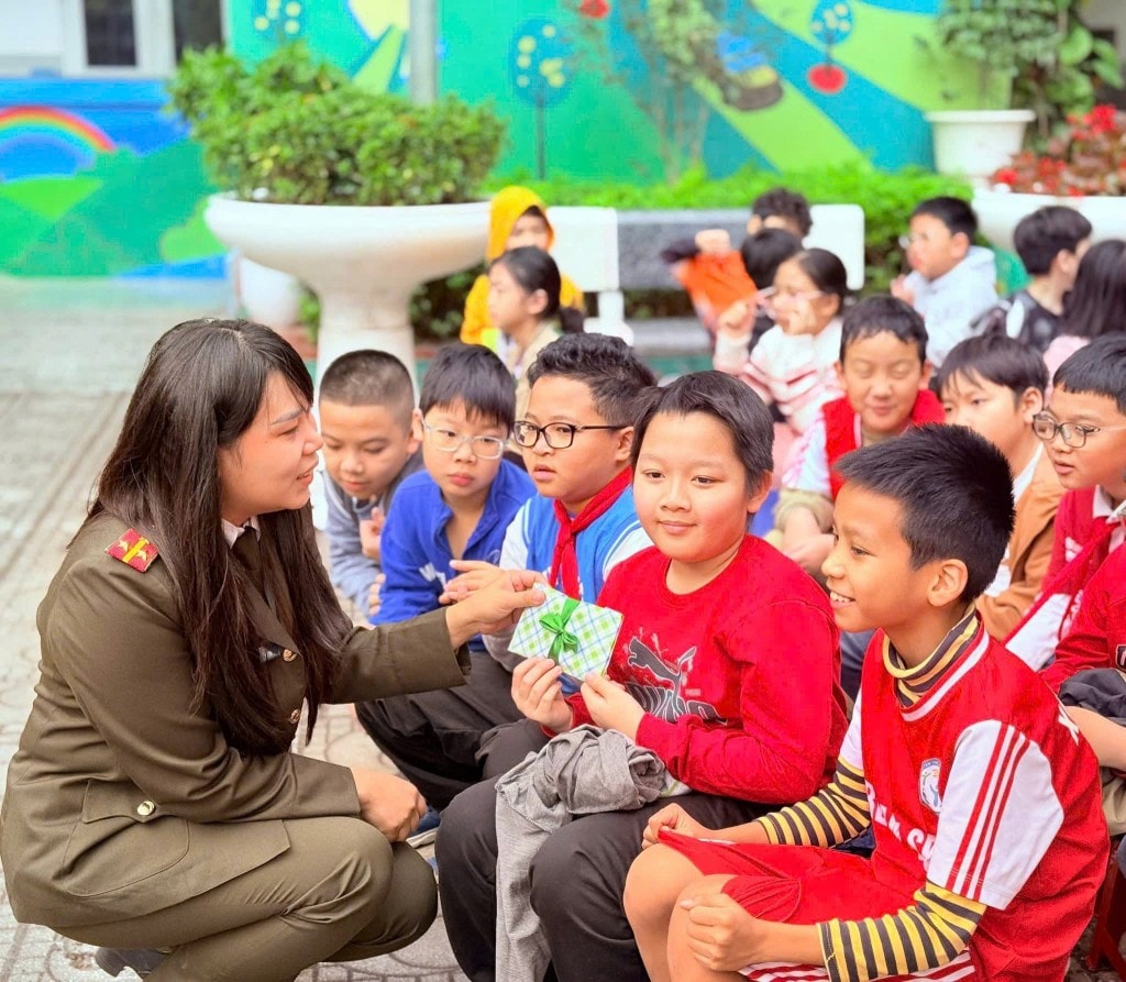 Cán bộ Công an phường Kim Liên giao lưu, hướng dẫn học sinh Trường Tiểu học Trung Tự nhận diện tình huống nguy cơ trong môi trường học đường.