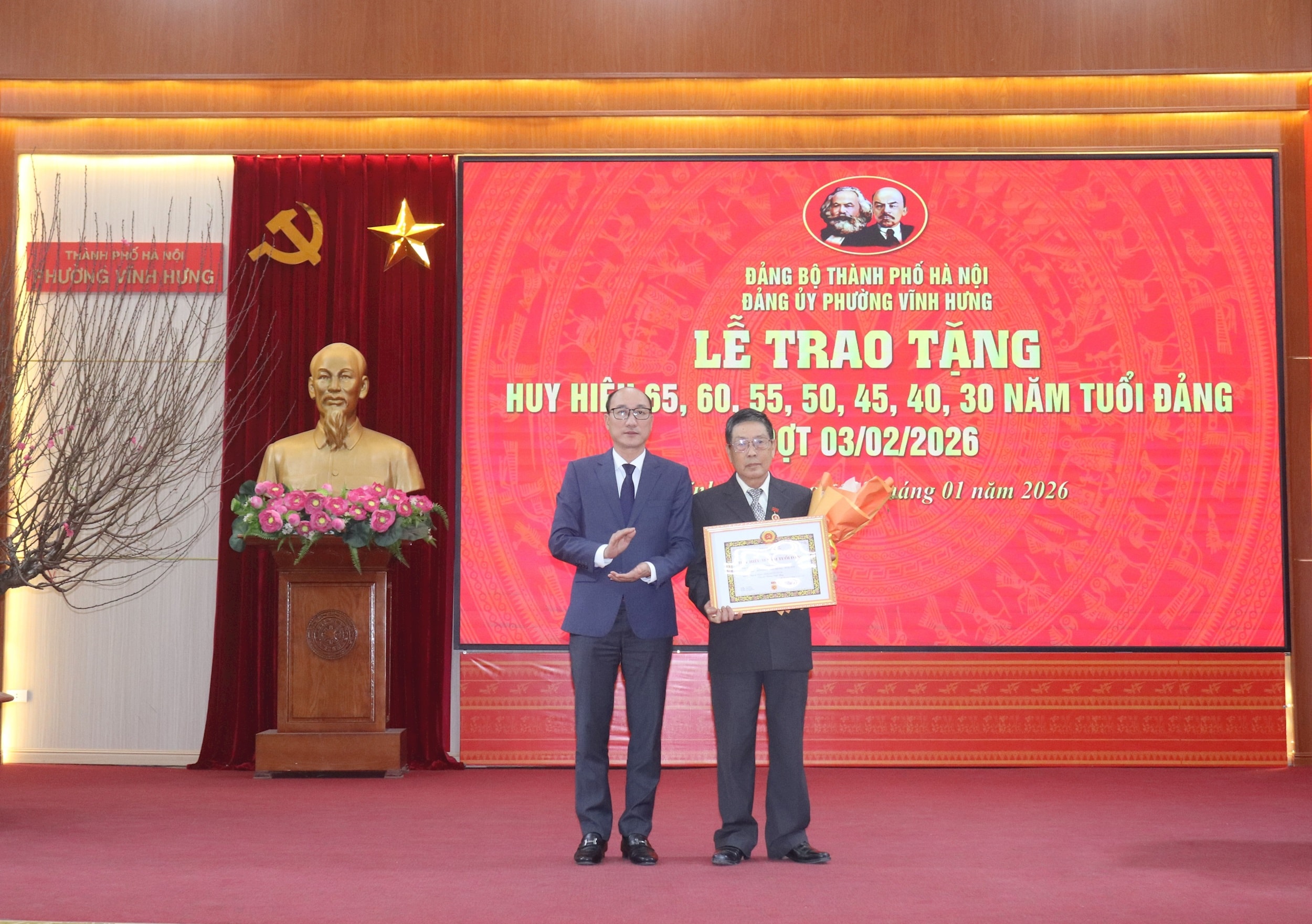 Phó Bí thư Đảng ủy, Chủ tịch UBND phường Vĩnh Hưng Phạm Hải Bình trao Huy hiệu 55 năm tuổi Đảng tặng đảng viên. Ảnh: Hiền Thu