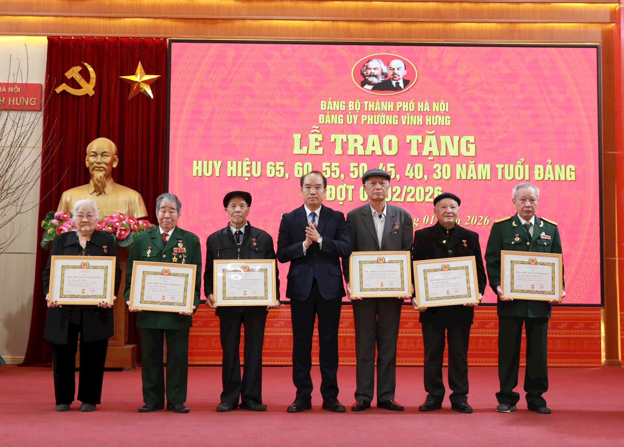 Phó Bí thư Thường trực Đảng ủy phường Vĩnh Hưng Nguyễn Anh Tuấn trao Huy hiệu 60 năm tuổi Đảng tă các đảng viên. Ảnh: Hiền Thu