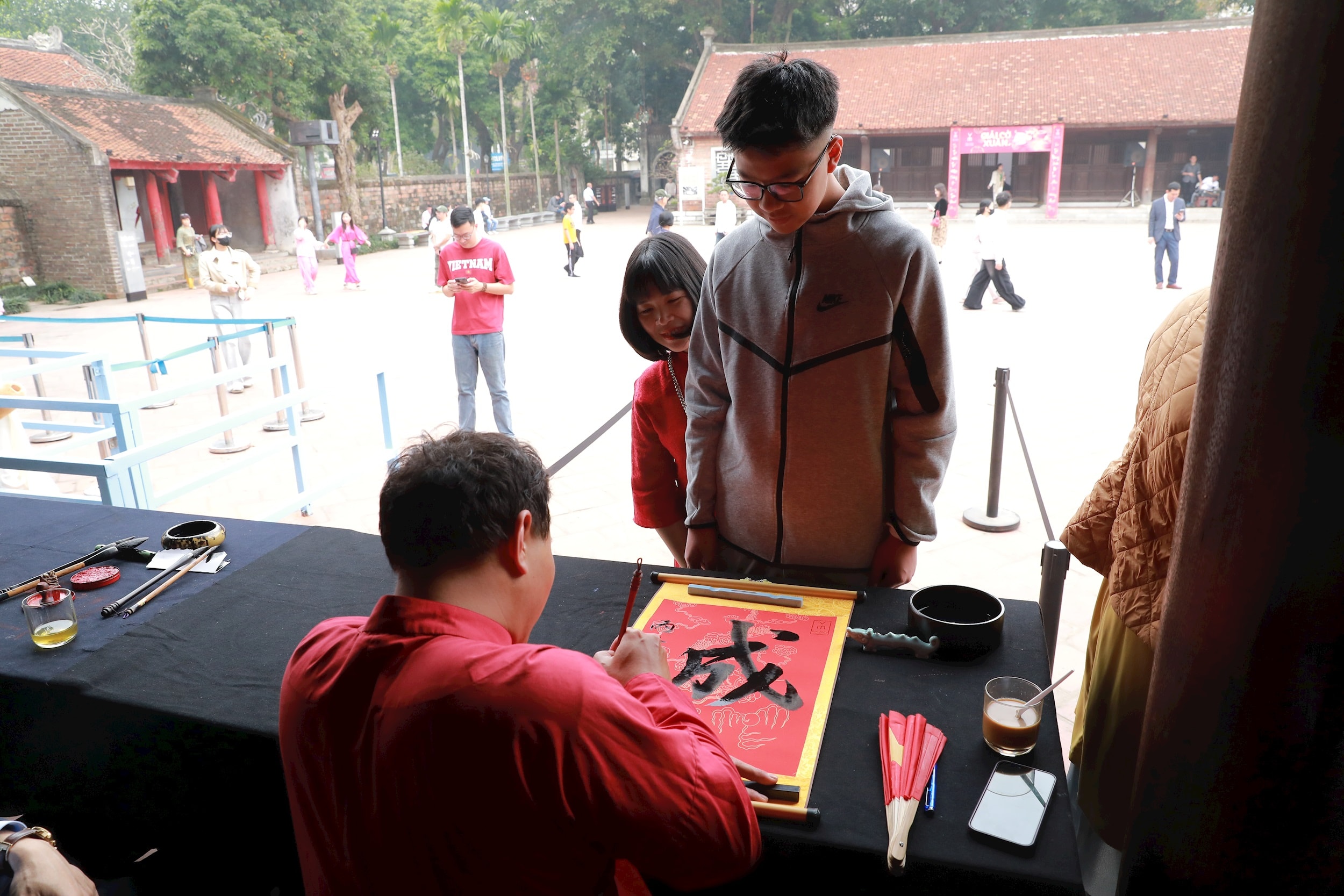 Каллиграф пишет каллиграфическим почерком Хан Ном на традиционной красной бумаге. Фото: Чи Хиеу.