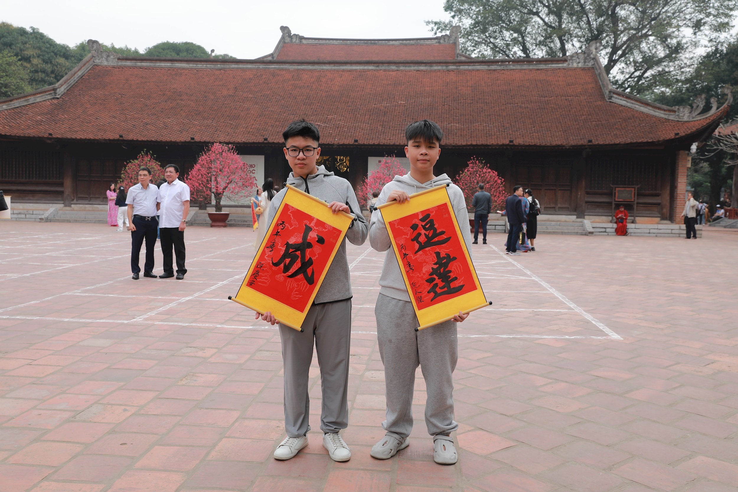 Двое учеников средней школы Ме Линь (Ханой) заказали каллиграфическое написание иероглифов «Дау Дат» и «Тхань» (что означает «Сдача экзаменов и достижение успеха»), надеясь успешно сдать экзамены и преуспеть в учебе в год Лошади (Бинь Нго). Фото: Чи Хиеу