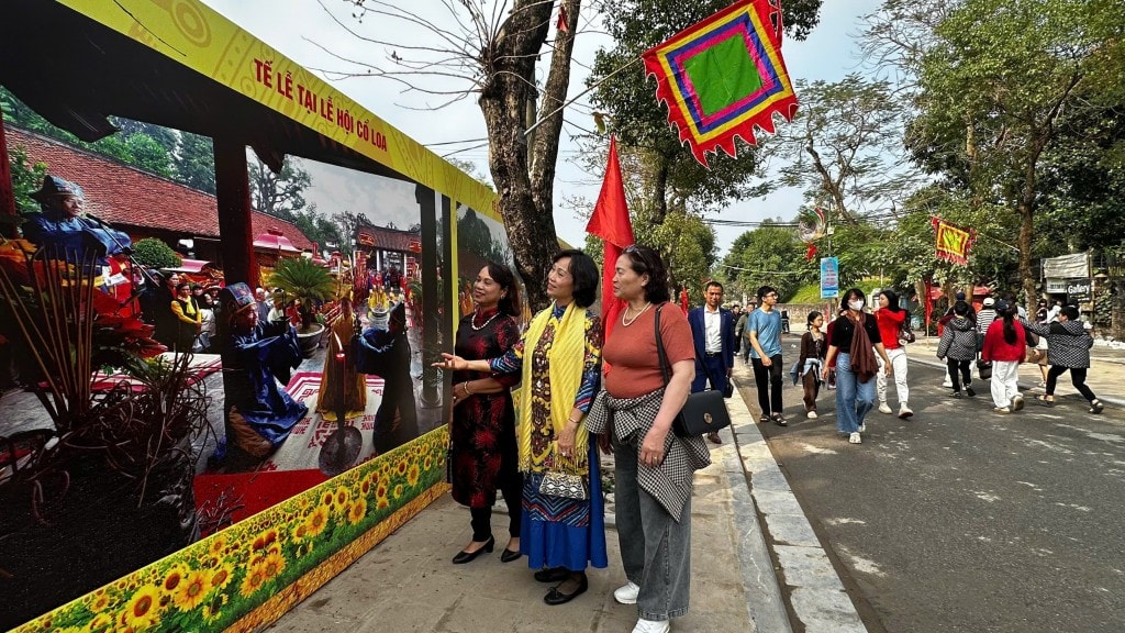 La signora Mai Kim Bich (distretto di Hoan Kiem, Hanoi) e i suoi parenti visitano l'area della mostra fotografica al festival (Foto: Thai Son)
