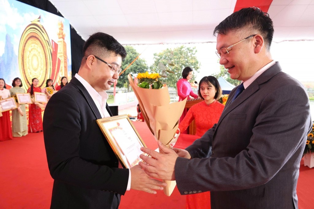 Bí thư Đảng ủy, Chủ tịch HĐND xã Mê Linh Nguyễn Anh Tuấn trao giải cho tác giả có tác phẩm xuất sắc tại cuộc thi “Ứng dụng trí tuệ nhân tạo (AI) xây dựng video, clip với chủ đề: Mê Linh tôi yêu”. Ảnh: Vũ Cường.