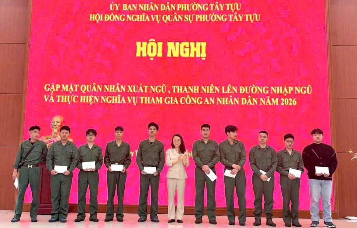 Phó bí thư Thường Trực đảng uỷ phường Tây Tựu Nguyễn Thị Nắng Mai tặng quà thanh niên nhập ngũ. (Ảnh: TT)