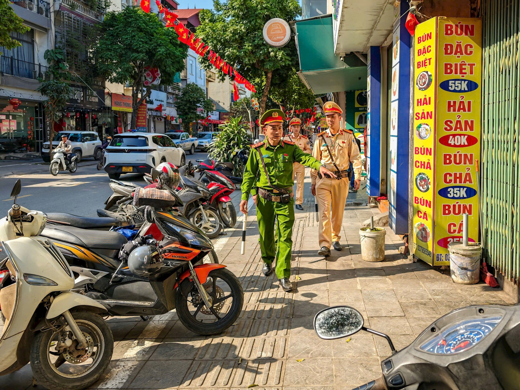 Cảnh sát giao thông phối hợp với các lực lượng chức năng xử lý vi phạm về trật tự đô thị. Ảnh: Hồng Nhung
