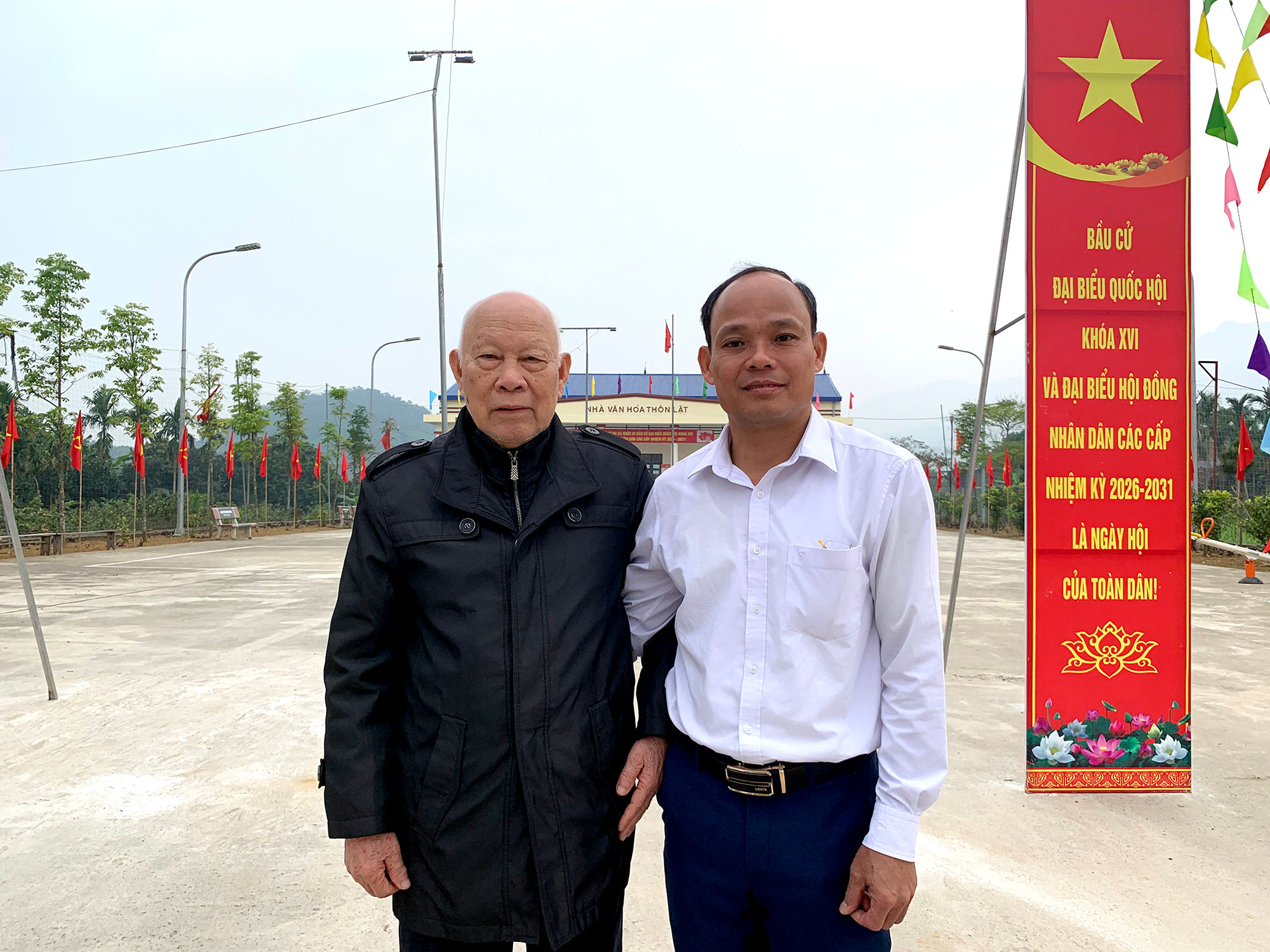 1Cụ Đinh Văn Tề (88 tuổi) và đồng chí Đinh Xuân Ngoan, Ủy viên Ban Thường vụ Đảng ủy, Phó Chủ tịch HĐND, Phó Chủ tịch Ủy ban Bầu cử xã Ba Vì trao đổi với PV tại điểm bầu cử Nhà văn hoá thôn Lặt