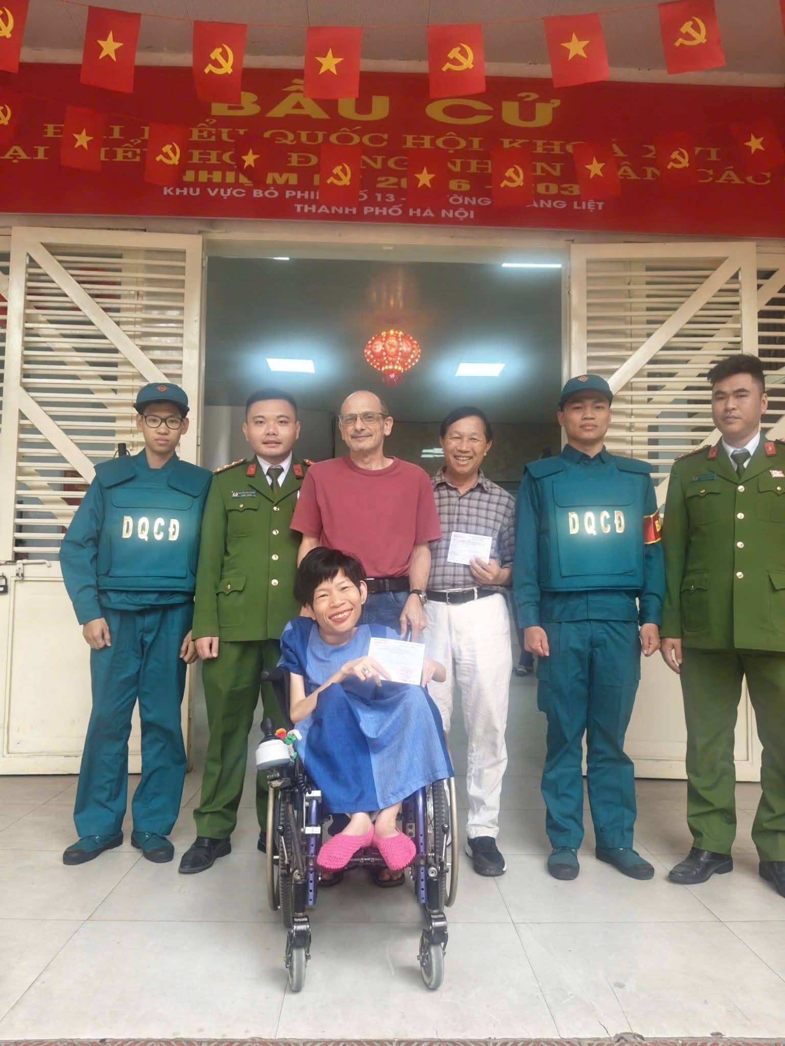 Anh Neil Bowden (người đẩy xe, quốc tịch Úc) ấn tượng trước tinh thần trách nhiệm của các thành viên tổ bầu cử. Ảnh TĐ