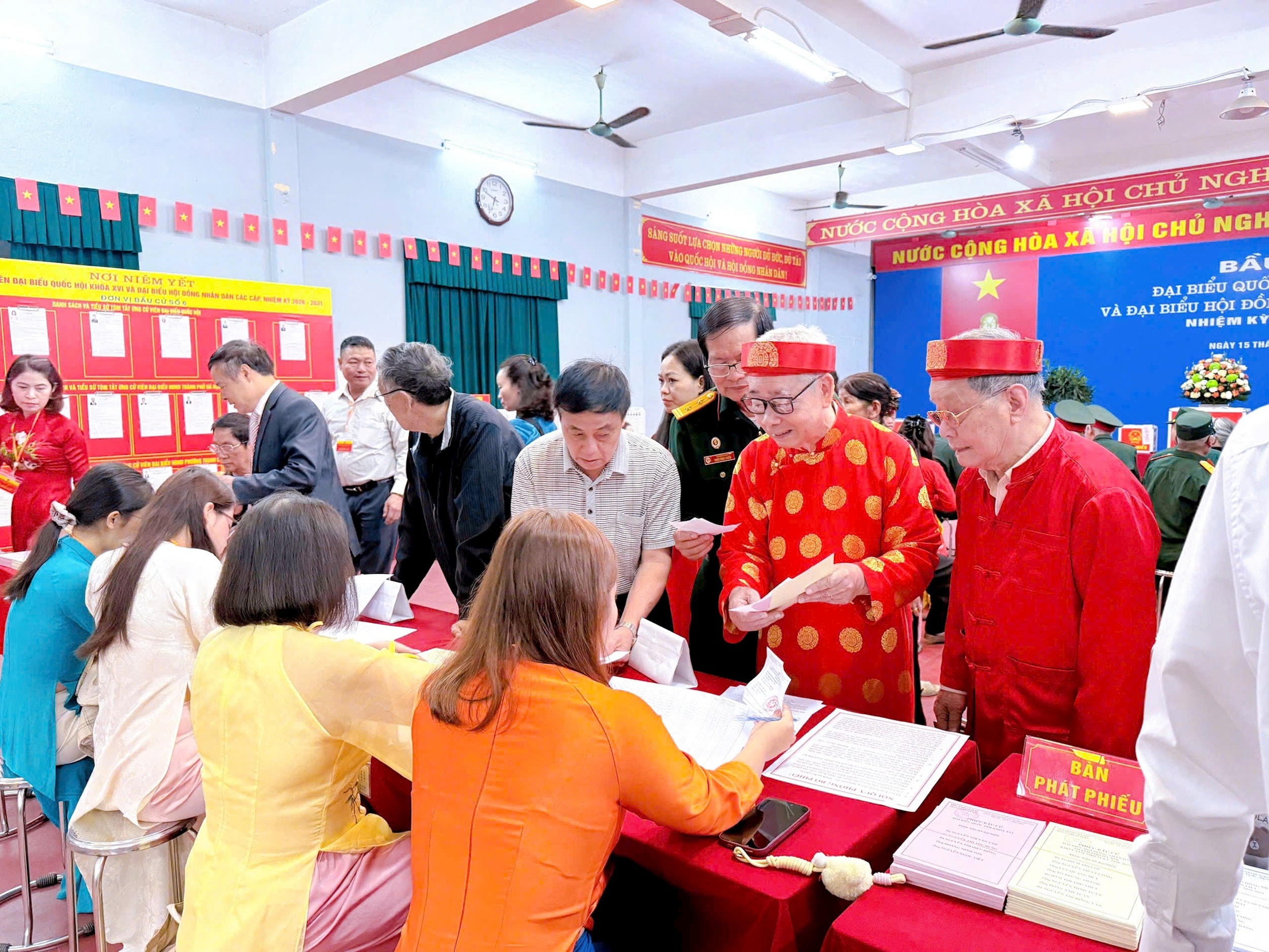 Các cử tri tại khu vực tổ bỏ phiếu số 6, khu vực bỏ phiếu số 24 phường Thanh Liệt phấn khởi nhận những lá phiếu từ bàn phát phiếu để tự tay mình bỏ vào hòm phiếu. Ảnh: Đào Tuyết