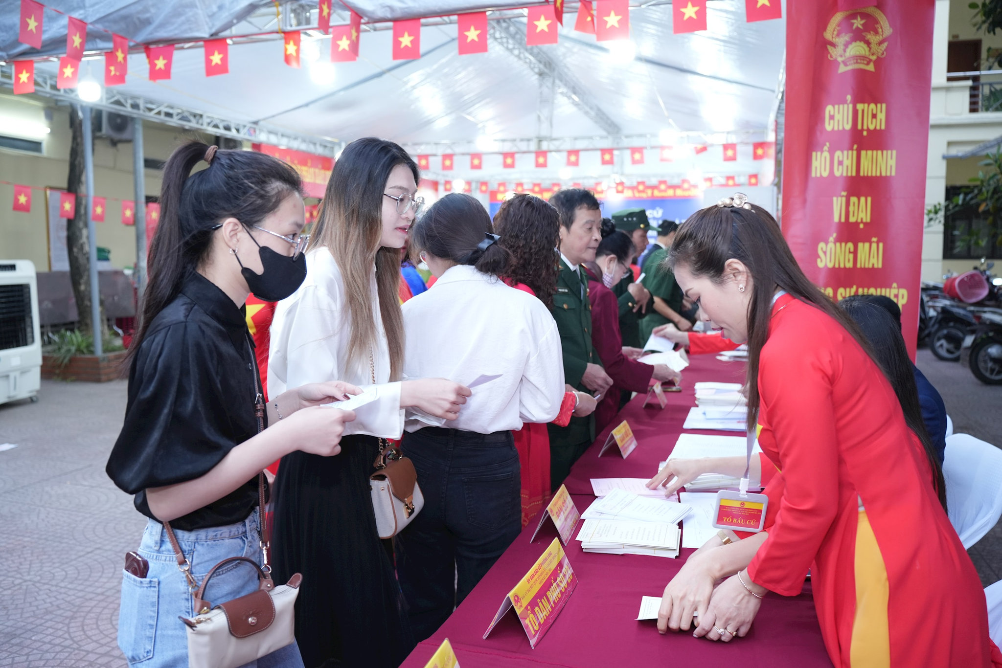 Các cử tri xếp hàng chờ đến lượt nhận phiếu bầu cử