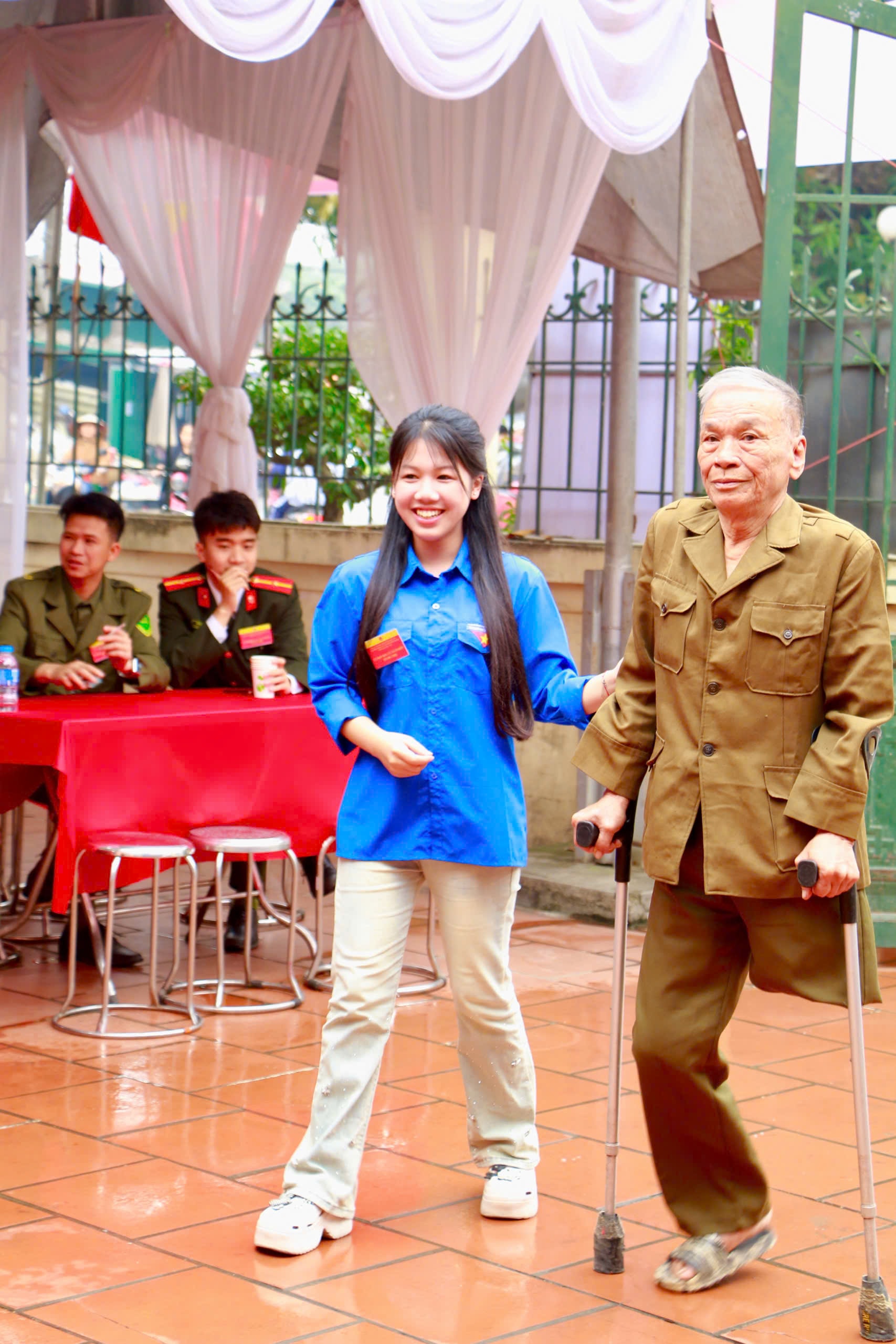 Đoàn viên thanh niên xã Ô Diên hỗ trợ cử tri Nguyễn Hữu Cờ, 75 tuổi thương binh ¼, bỏ phiếu tại khu vực bầu cử số 13 (khu vực Liên Hà, xã Ô Diên). Ảnh: Hữu Phượng