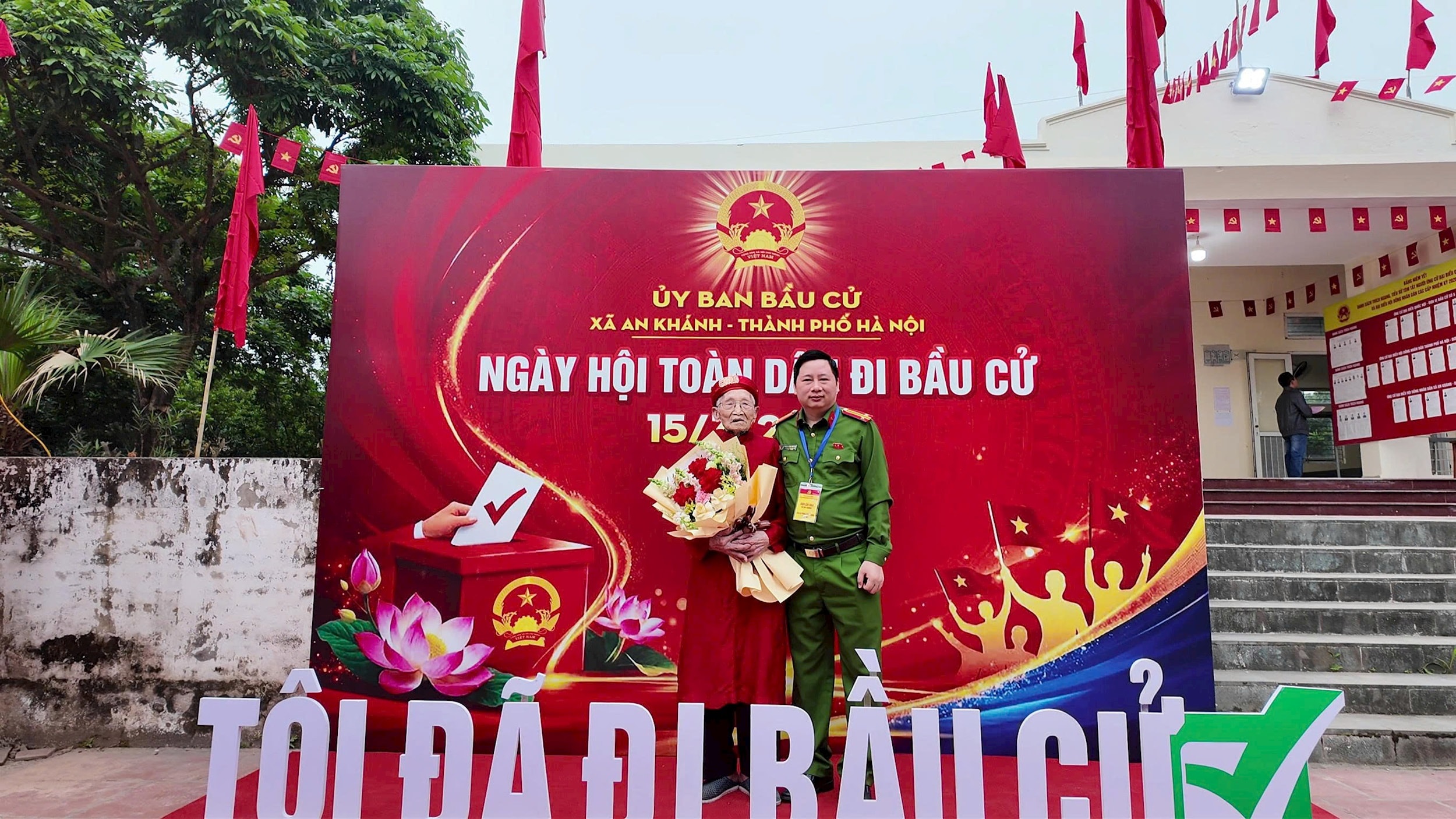 Sau khi thực hiện xong nghĩa vụ công dân, cử tri Nguyễn Văn Pha cũng tranh thủ check-in cùng lãnh đạo Công an xã An Khánh. Ảnh: Hoàng Phương