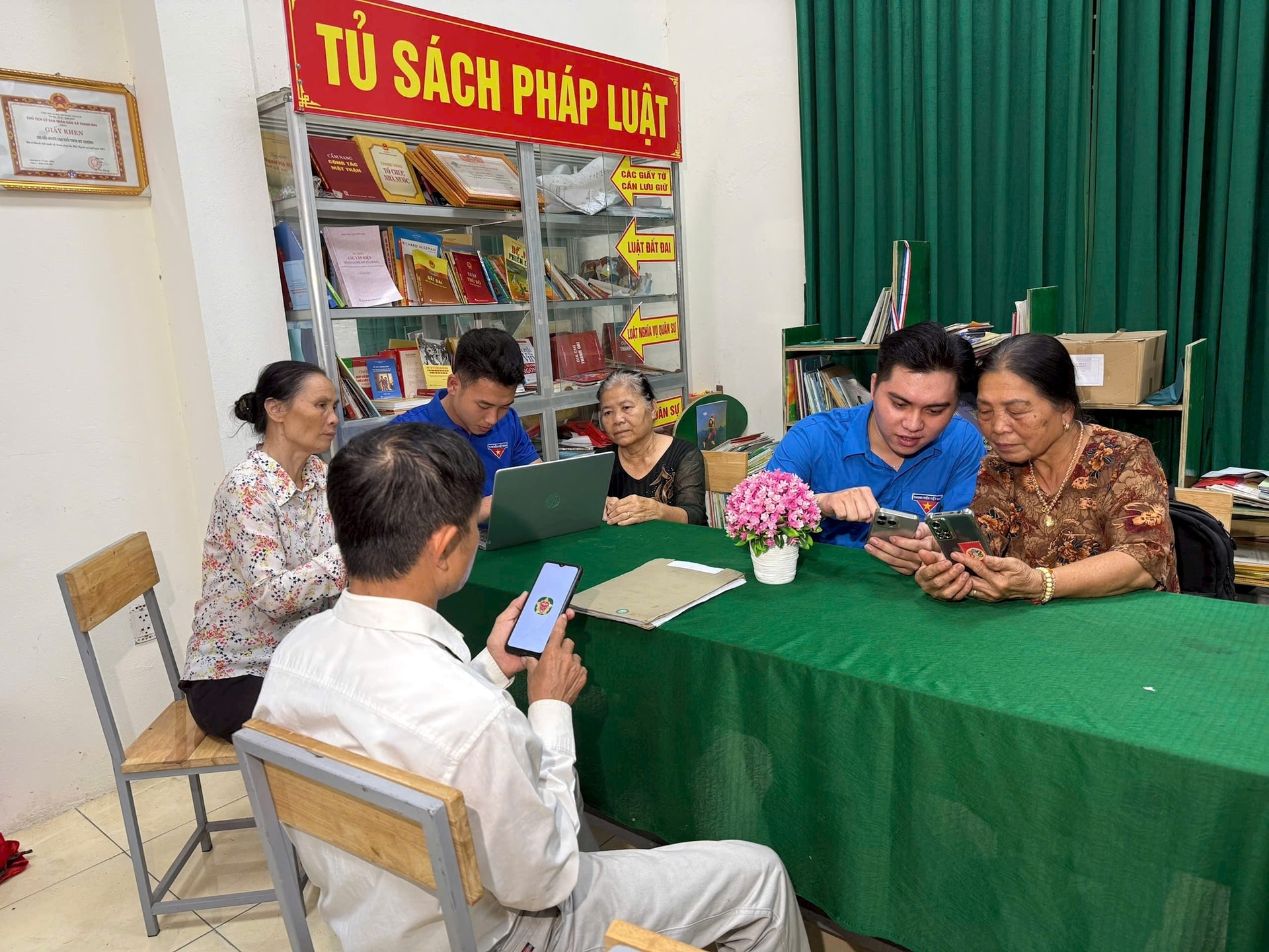 Đoàn viên Thanh Oai hỗ trợ bà con tiếp cận dịch vụ công trực tuyến tại điểm sinh hoạt số cộng đồng - Nhà văn hóa thôn My Thượng. Ảnh: Minh Thuý