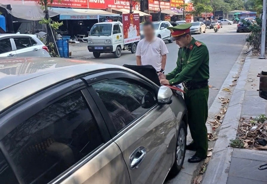 Lực lượng chức năng phường Cầu Giấy xử lý trường hợp dừng đỗ phương tiện sai quy định. Ảnh: Trần Trung