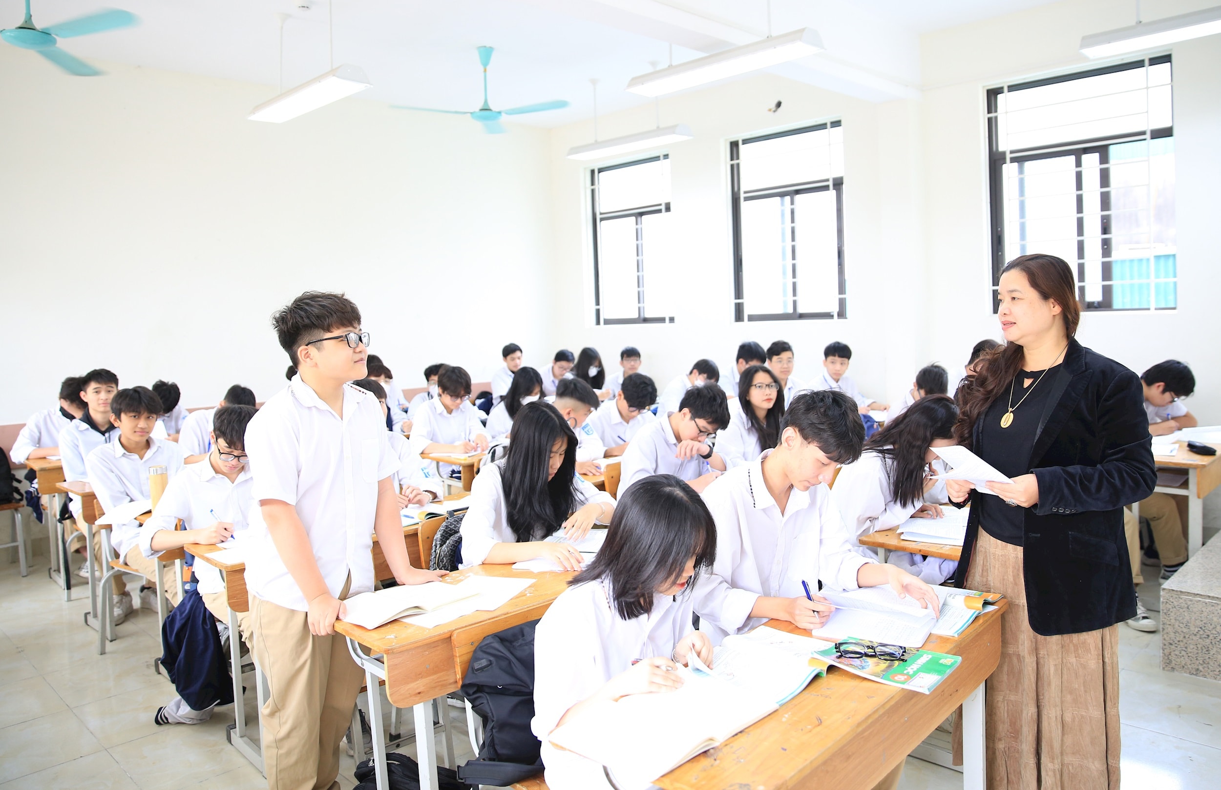 ครูโรงเรียนมัธยมปลาย Truong Dinh Phuong Hoang Mai กำลังแนะนำนักเรียนชั้นมัธยมศึกษาปีที่ 6 ในการทบทวนบทเรียน - ภาพโดย Do Tam.jpg