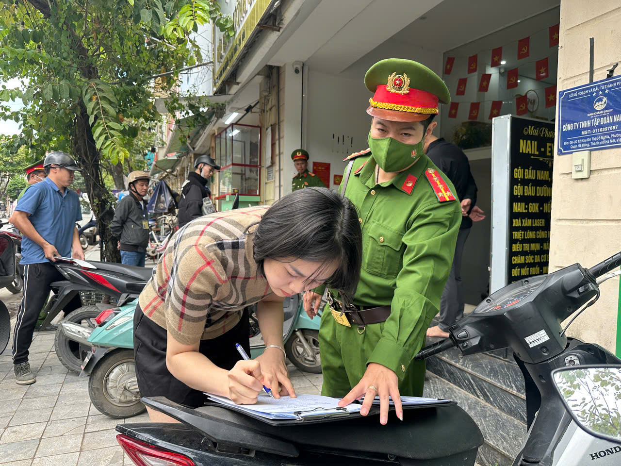 Người dân ký cam kết không lấn chiếm vỉa hè, lòng đường. Ảnh: VT