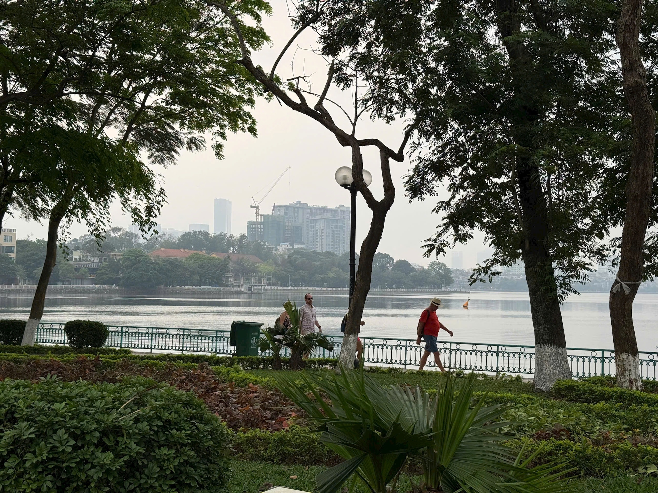 تصویر-۱-زیر-درختان-سبز-کنار-دریاچه-غرب-شرق-مردم-در حال قدم زدن-با فراغت-و-لذت بردن-از-لحظه‌ای-آرامش-در-قلب-شهر..jpg