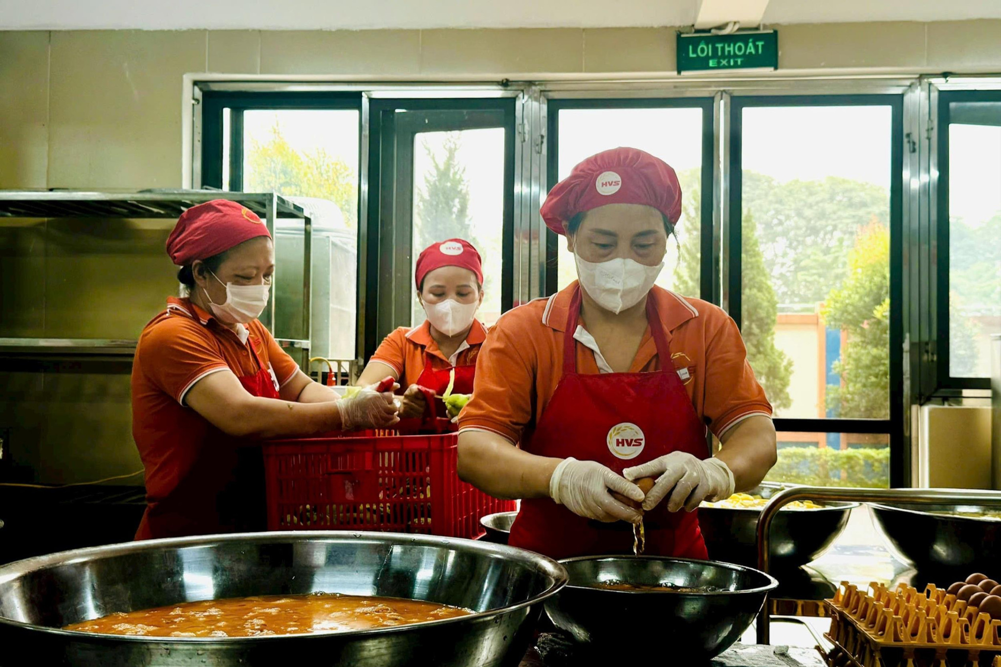 Thực hiện quy trình chế biến phục vụ bữa ăn bán trú tại bếp ăn Trường Tiểu học Đoàn Khuê, phường Việt Hưng. Ảnh: Mai Hoa