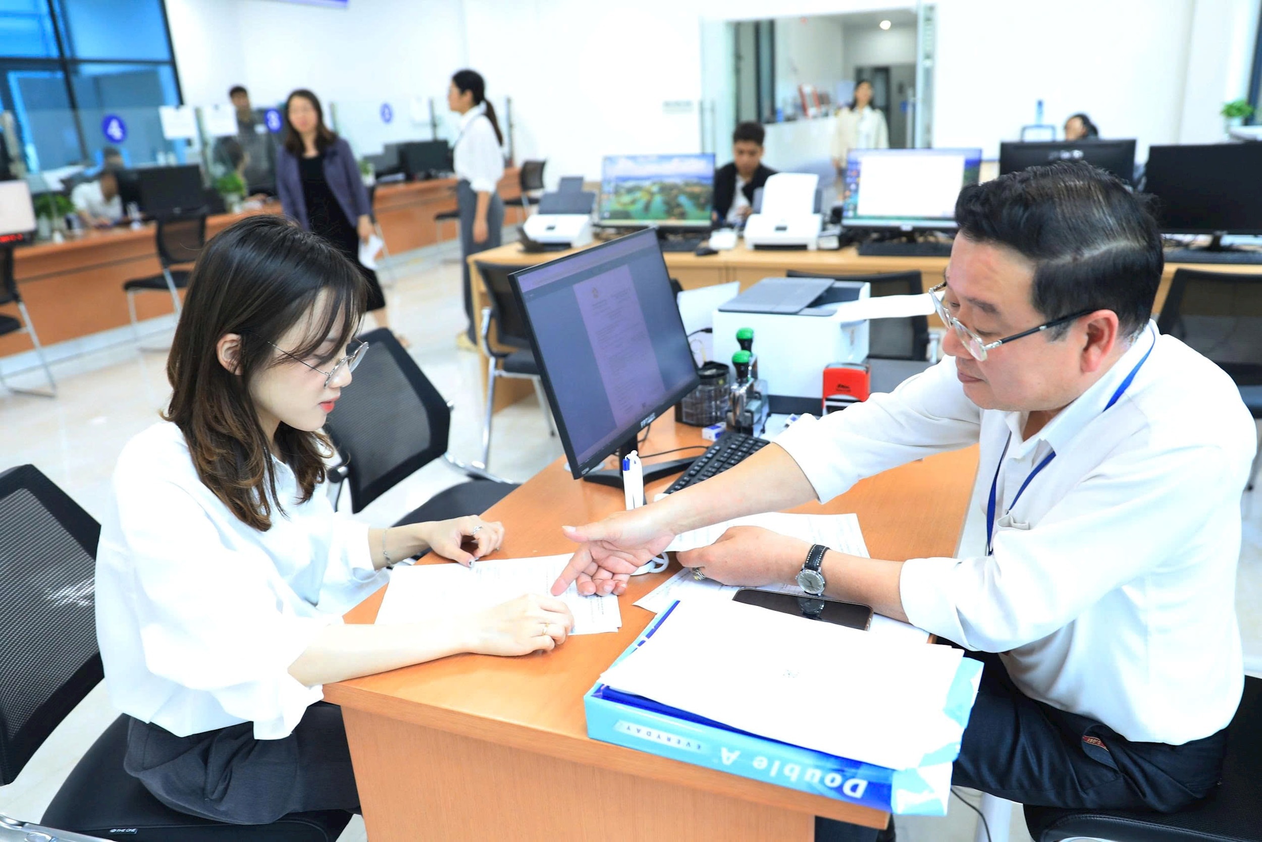 Hỗ trợ người dân giải quyết thủ tục hành chính trực tuyến tại Trung tâm Phục vụ hành chính công chi nhánh Cầu Giấy. Ảnh: Quang Thái