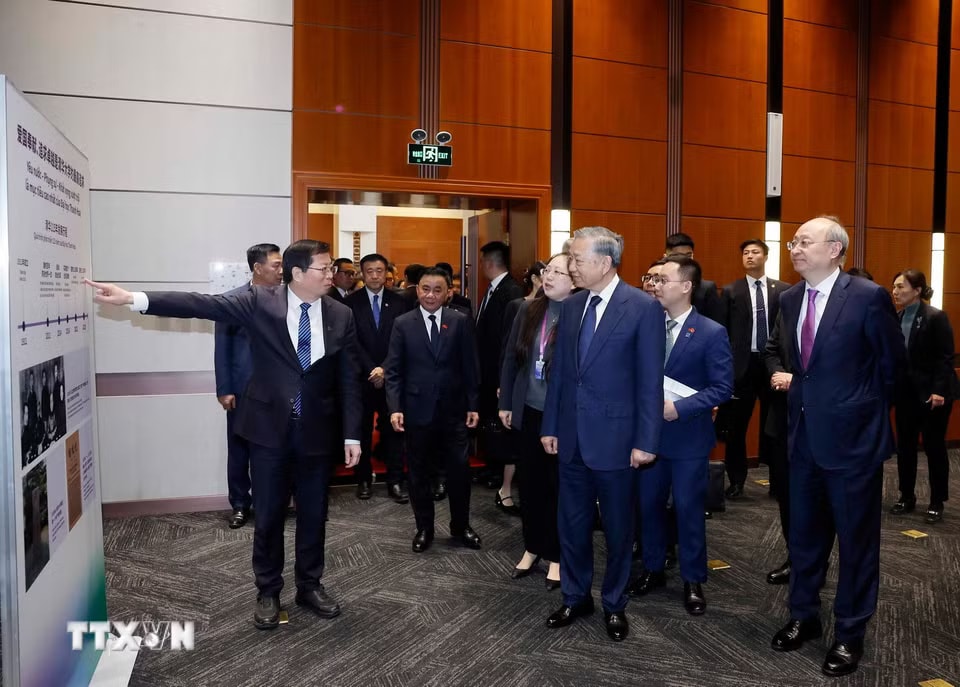 Tổng Bí thư, Chủ tịch nước Tô Lâm và đại biểu nghe giới thiệu về Đại học Thanh Hoa. (Ảnh: Thống Nhất/TTXVN)
