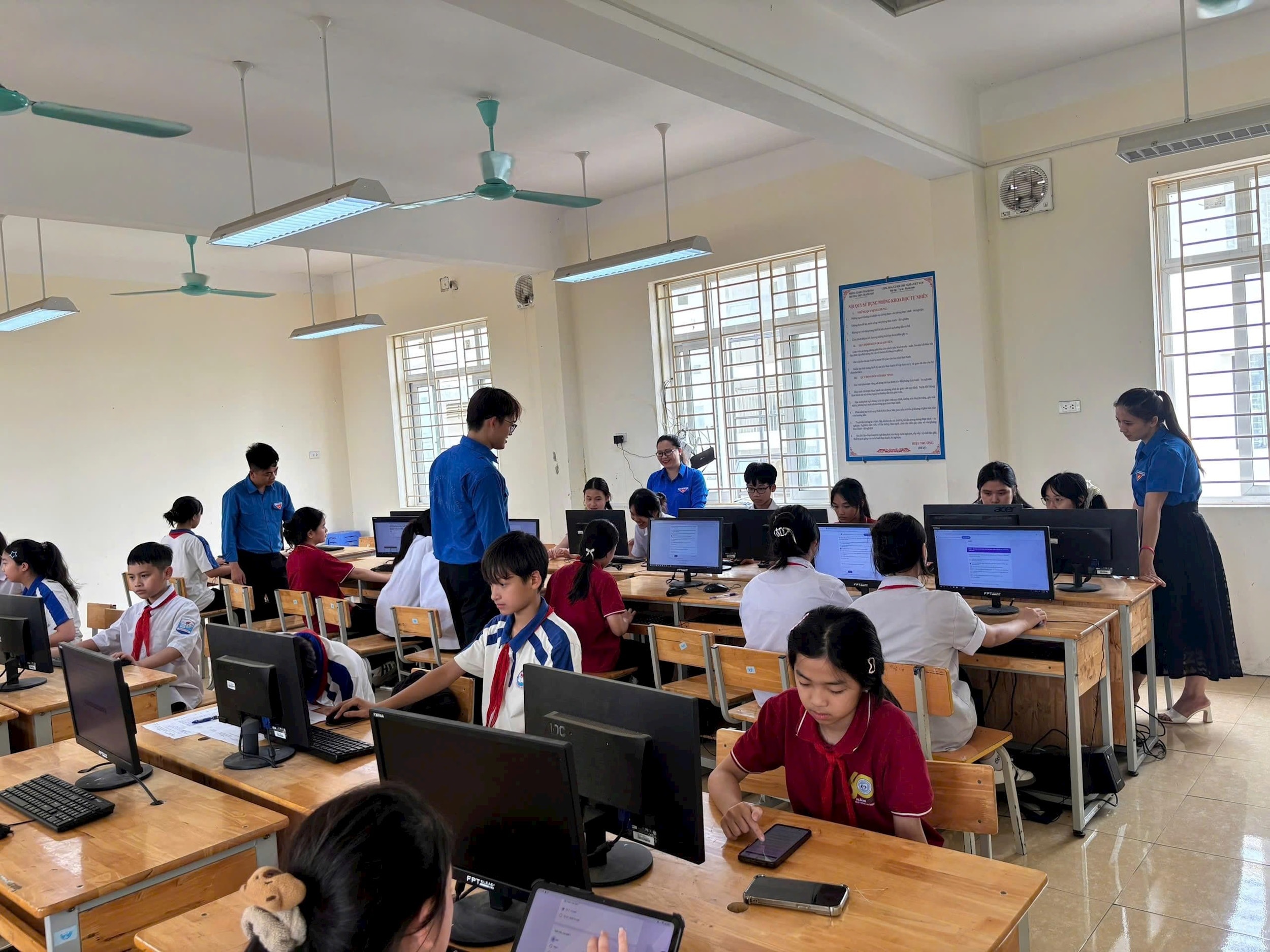 Đoàn viên, thanh niên xã Thanh Oai hỗ trợ các em thực hiện đóng góp ý kiến. Ảnh: 